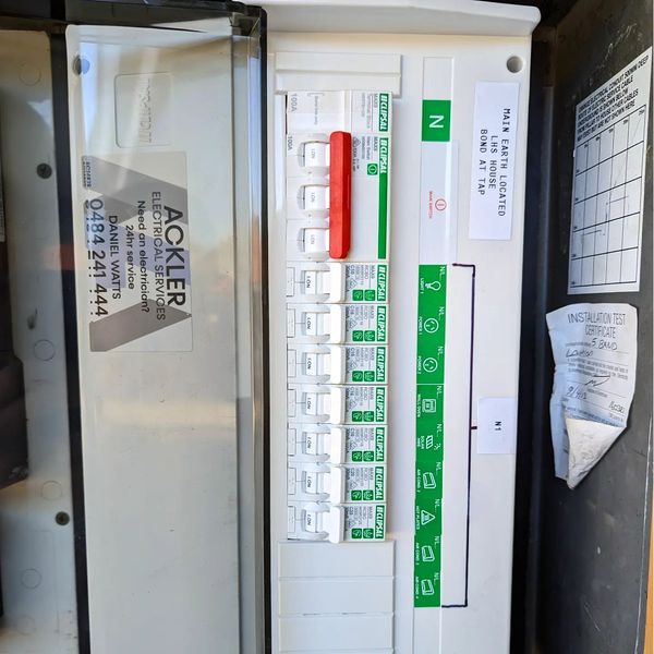 The image displays an electrical switchboard from Ackler Electrical Services. It features multiple circuit breakers, including RCDs (Residual Current Devices) and MCBs (Miniature Circuit Breakers) for circuit protection. The visible labels indicate the function and identification of each breaker, ensuring proper safety and management of the electrical system. This switchboard is likely part of a residential or commercial installation, essential for protecting circuits from overload and electrical faults. The prominent branding of Ackler Electrical Services reflects their professional identity in the electrical sector, and the area appears well-maintained.