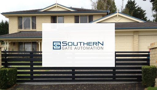 The image displays a contemporary two-storey home featuring a modern architectural design. The exterior is a light cream colour, with a dark tiled roof and blue accents on the eaves and windows. In the foreground, there is a sleek, black automated gate that enhances the property's security and aesthetic appeal. The driveway is paved with stone and is bordered by low hedges, creating a welcoming entrance. This setting exemplifies the intersection of modern living and smart home solutions, ideal for showcasing Southern Gate Automation's services.
