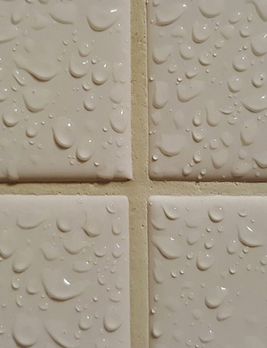 The image features a close-up view of white tiles, which are visibly covered in droplets of water. This suggests that they have recently been cleaned or that moisture is present. The clean and shiny appearance of the tiles indicates a high standard of cleanliness, which aligns with the values and services of House Cleaning Cronulla. The focus on water droplets highlights the effectiveness of the cleaning process, demonstrating that surfaces can be left spotless and well-maintained. This is particularly relevant for commercial cleaning services, where such attention to detail is essential for creating a professional and hygienic environment in offices, warehouses, and other facilities.