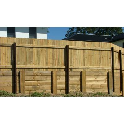 Installing a butted pine timber fence on top of an existing retaining wall using support post.